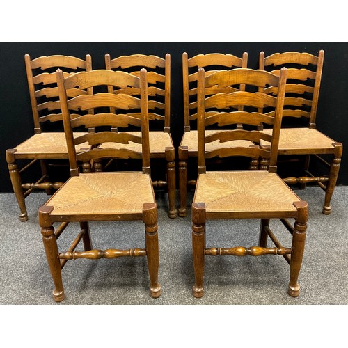 85 - A set of six ladder-back 19th century style elm dining chairs, and a matching carver chair, rush sea... 