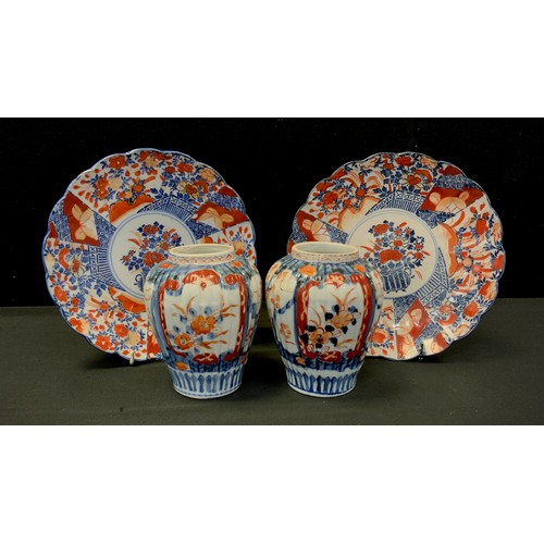 146 - A pair of Japanese Imari plates, traditionally decorated with gardens flowers and trellis panels, 21... 