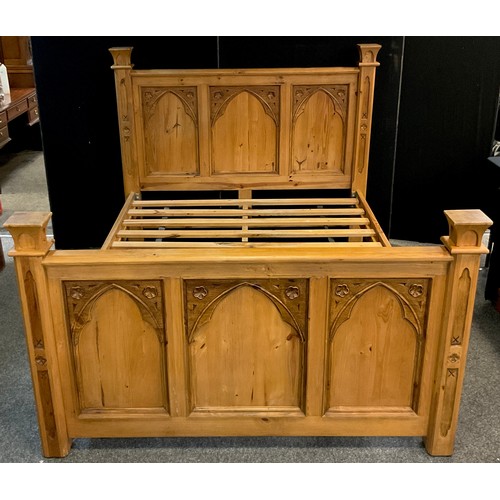 105 - A Gothic style pine King-size bed, 142cm high at headboard x 228cm x 171cm overall (200cm x 153cm ma... 