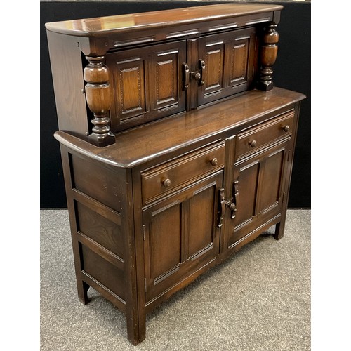 285 - An Ercol ‘Old Colonial’ elm court cupboard, 124.5cm high x 118.5cm wide x 45cm deep.