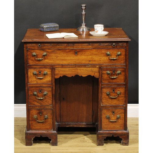 1228 - A George III mahogany kneehole desk, the ovolu moulded top above a brushing slide, axe head handles,... 