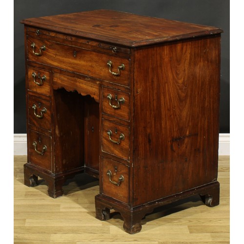 1228 - A George III mahogany kneehole desk, the ovolu moulded top above a brushing slide, axe head handles,... 