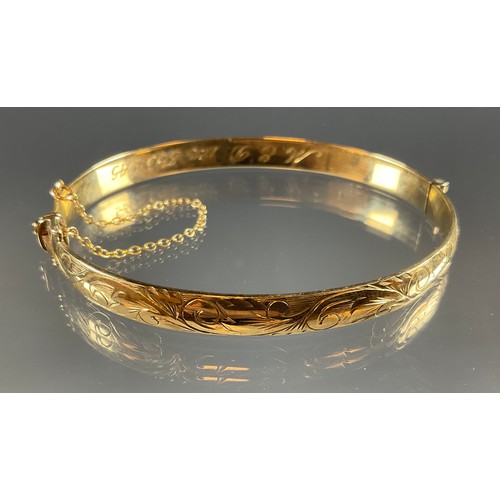 405 - A 9ct gold hinge bangle, engraved EMD 1945, 17.4g gross