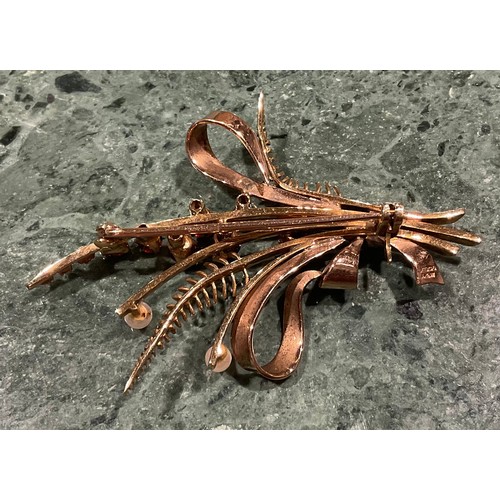 943 - A 9ct gold garnet and seed pearl brooch, cast as a spray of ribbon tied ferns and budding stems, the... 