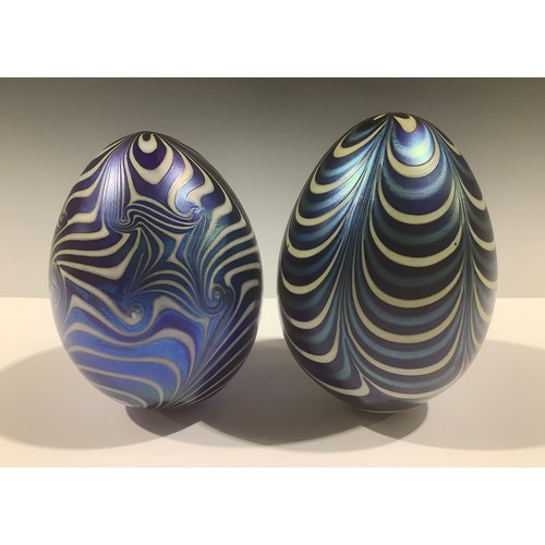 5117 - A matched pair of Vandermark opalescent glass eggs, in lustrous shades of blue and white, the smalle... 