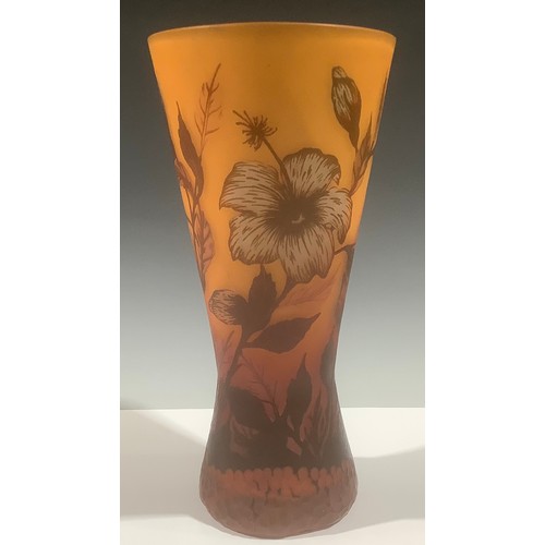 5119 - A cameo glass waisted cylindrical vase, with leafy flowers in shades of red on an orange ground, unm... 