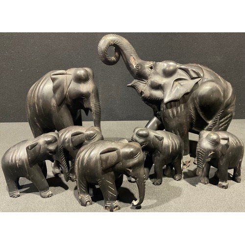 5243 - A set of seven carved ebonised Elephant family models, the largest 27cm high