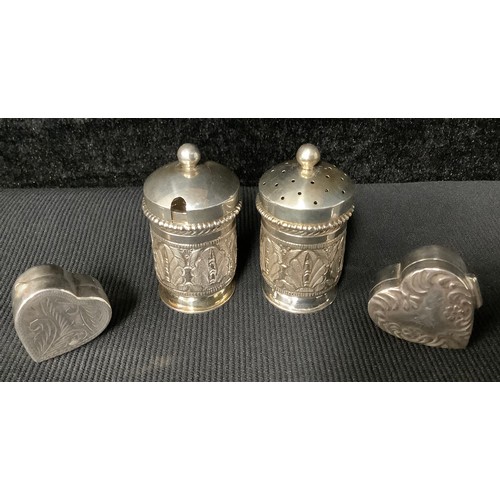 5256 - Two silver heart shaped pill boxes or bonbonnieres; a pair of Malaysian silver condiments (4)