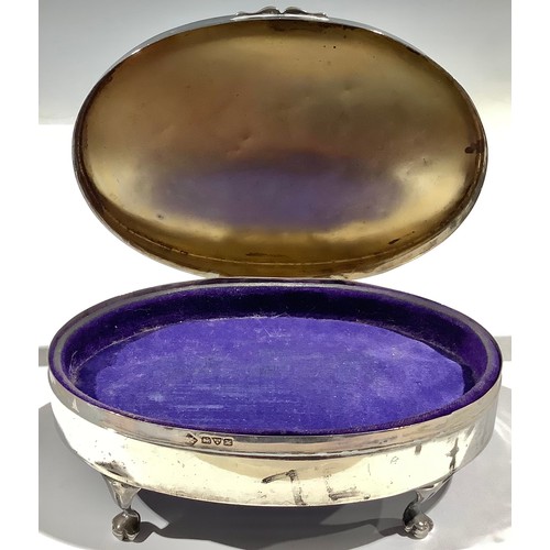 5026 - A silver oval dressing table box, engine turned hinged cover, paw feet, 14cm wide, Chester 1908, 149... 