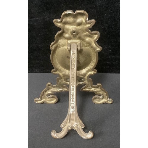 5420 - A 19th century Rococo Revival brass easel pocket watch stand, topped with a pair of intertwined putt... 