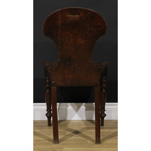 1543A - A Victorian oak hall chair, shaped back carved and applied with a shield, turned forelegs, 86cm high... 