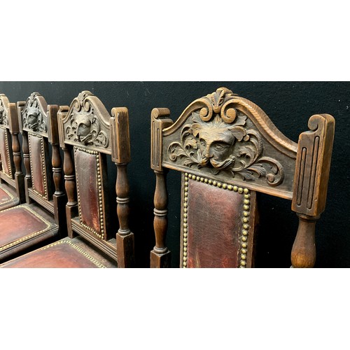 47 - A set of four Victorian carved oak dining chairs, the top rail carved with a ‘Green-man’ style mask,... 