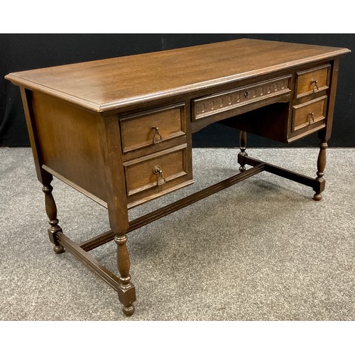 91 - A dark oak desk / writing table, single long drawer to frieze, with pair of short drawers each side,... 