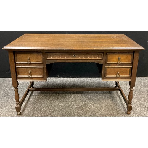 91 - A dark oak desk / writing table, single long drawer to frieze, with pair of short drawers each side,... 