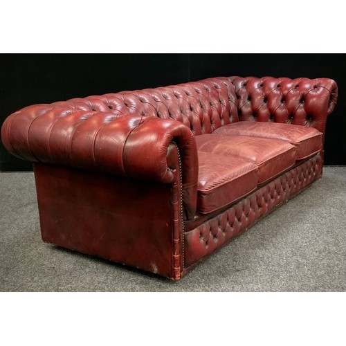 201 - An Oxblood red leather chesterfield three seater sofa, 67cm high, 200cm wide, 90cm deep, seat height... 