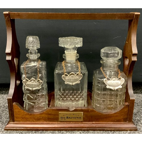 208 - A three bottle mahogany tantalus by the Balvenie with cut glass decanter’s. 30cm high x 34cm wide x ... 