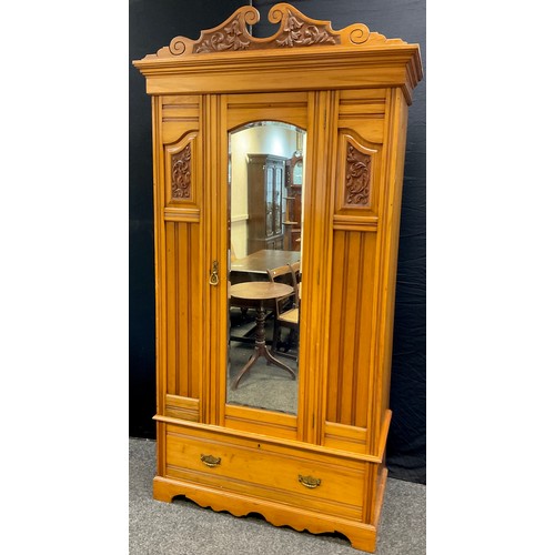 74A - An Edwardian Satinwood wardrobe, carved swan-neck cornice, bevelled mirror to centre door, single lo... 