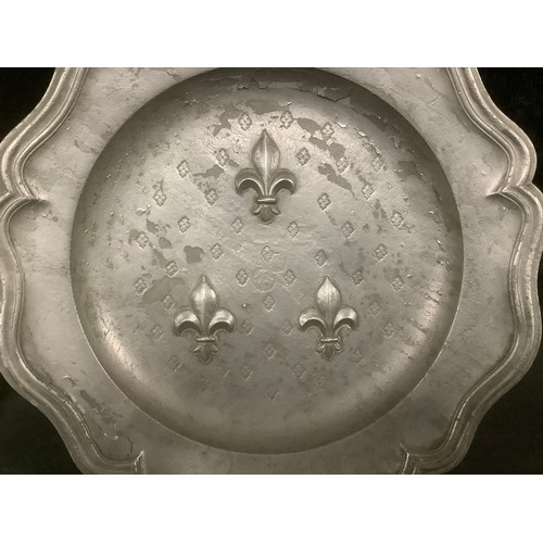 3054 - A pewter heavy gauge shaped circular plate, the central field embossed with the Guildford coat of ar... 