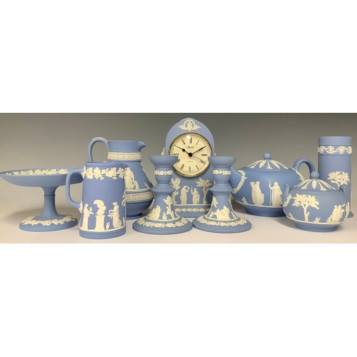 3172 - A Wedgwood Jasperware arched mantel clock, 19.5cm; a pair of candlesticks, 12cm; a teapot, sucrier a... 