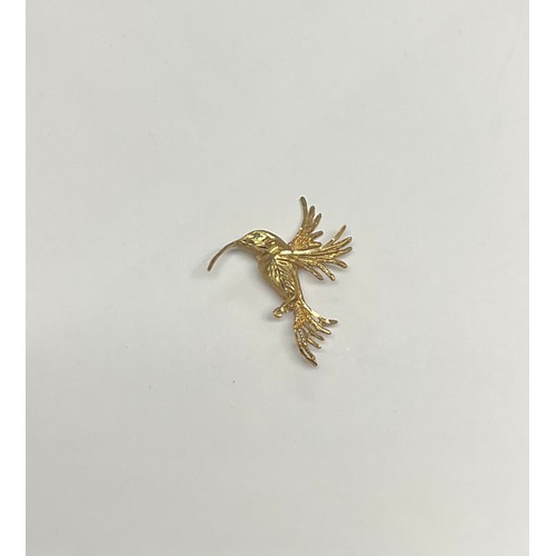 3369 - A 9ct gold Hummingbird brooch, as a bird in flight, the feathers bright cut and engraved, single gre... 