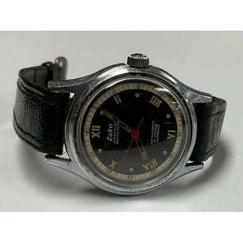 3380 - An Eska military watch, steel case, block dial, white chapter ring, black leather strap.