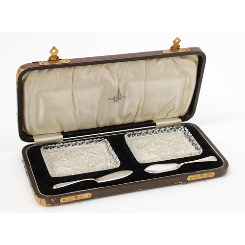 112 - A George V silver and cut glass tête-à-tête butter dish set, comprising two rectangular shaped cut g... 