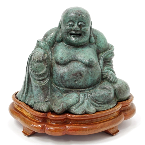 114 - Chinese School, a verdigris patinated bronze, of Budai, seated, 23cm high, wooden stand