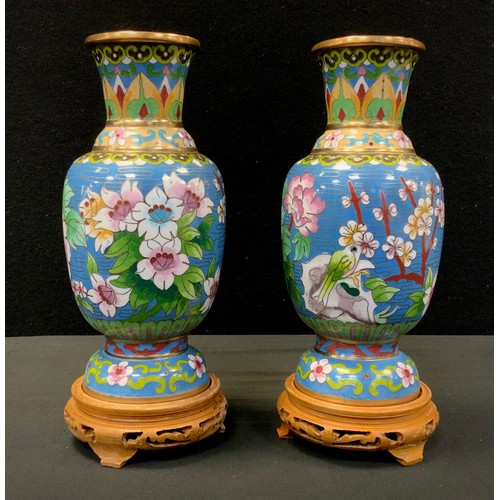 85 - A Pair of Japanese cloisonné vases, decorated with birds and flowers, blue ground, carved wooden sta... 