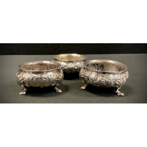 305 - A set of three Victorian Provincial Exeter silver open table salts, embossed floral bodies, tripod f... 