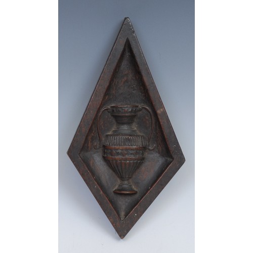 203 - A 19th century oak lozenge shaped panel, carved in relief with a Classical urn, 22cm x 12cm; another... 