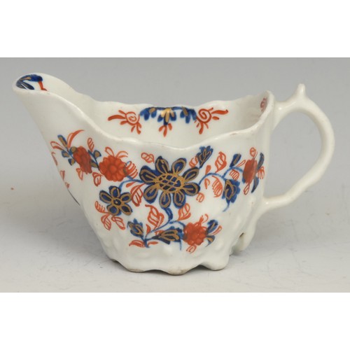 255 - A Lowestoft Low Chelsea ewer, decorated in underglaze blue and overglaze red with flowers and foliag... 