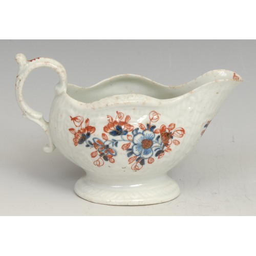 256 - A Liverpool cream boat, decorated in underglaze blue and overglaze red with flowers, picked out in g... 