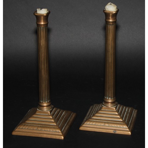 302 - A pair of George III brass fluted square candlesticks, of seamed construction, stepped square bases ... 