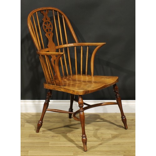 279 - A yew, beech and elm wheelback Windsor elbow chair, saddle seat, turned legs, crinoline stretcher, 1... 