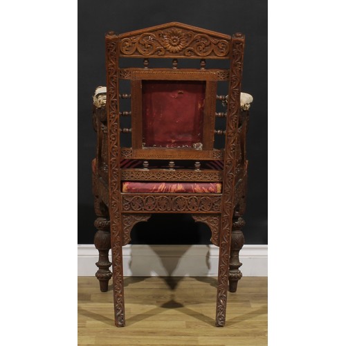 367 - A pair Anglo-Indian hardwood armchairs, carved throughout with scrolls, flowers and typical motifs, ... 