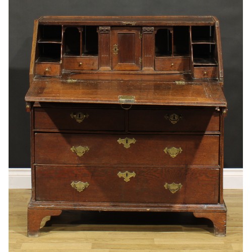 368 - An early George II oak bureau, fall front enclosing a well, a small door, small drawers, pigeonholes... 