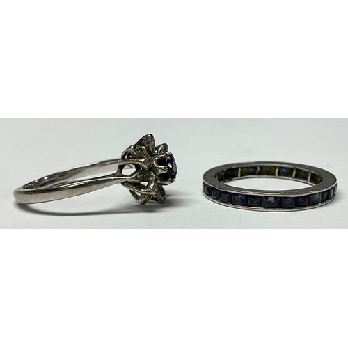 435 - An unmarked white metal eternity ring, set with a band of blue stones, size N, 2.4g; an unmarked clu... 