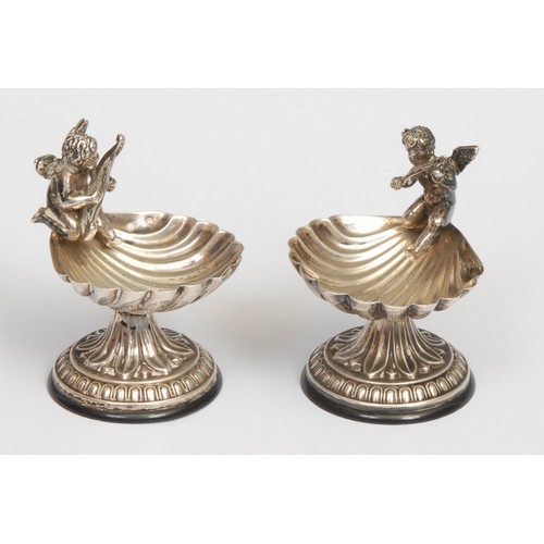 410A - A pair of early 20th century Continental silver coloured metal salts, each as a shell surmounted by ... 