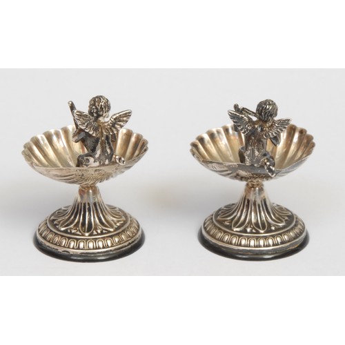 410A - A pair of early 20th century Continental silver coloured metal salts, each as a shell surmounted by ... 