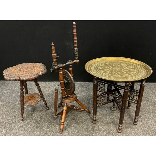 66 - An Indian carved occasional table, intricately decorated with a figure of a snake charmer, lizards a... 