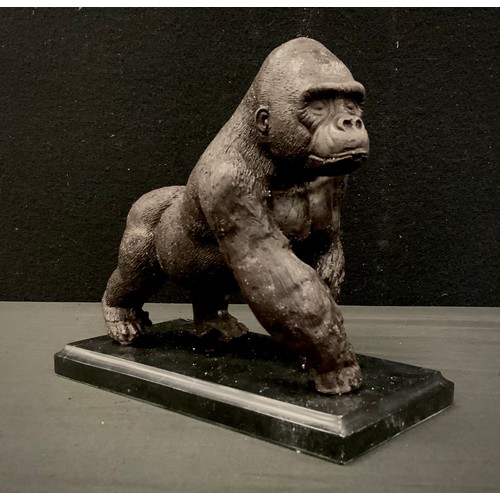 84 - A bronzed metal model of a gorilla on black marble plinth, 20cm long