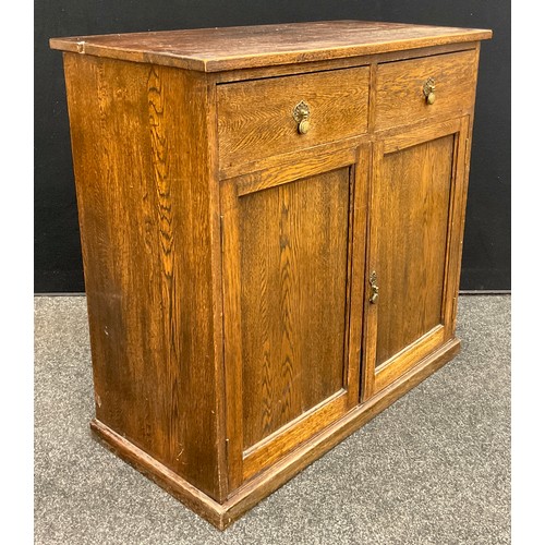 96 - An early to mid 20th century oak side cupboard, over-sailing rectangular top, pair of drawers to fri... 