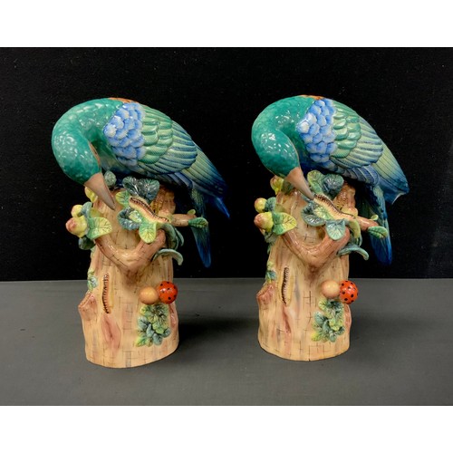 112 - A pair of porcelain green exotic birds on tree stump, faux Sevres mark, 29cm high (2)