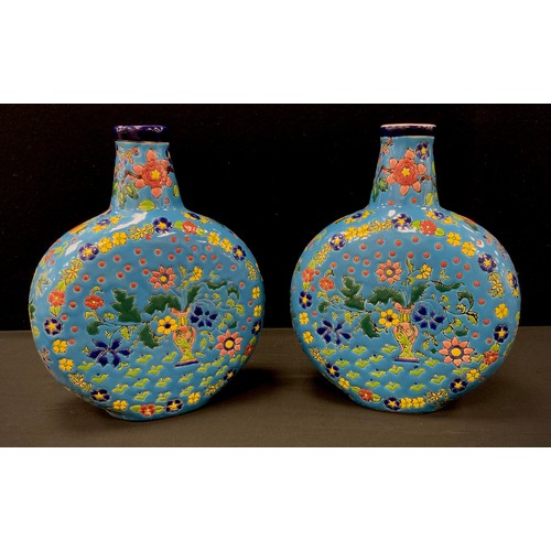 122 - A pair of powder blue moon flasks, decorated with multi coloured flowers, 28cm high (2)