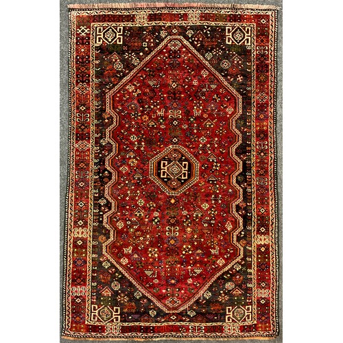 206 - A South West Persian Qashgai Carpet, hand-knotted in deep tones of red, grey, blue, and green, the c... 