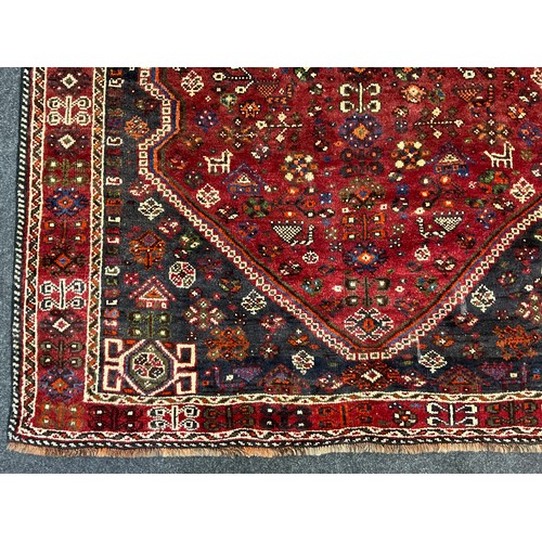 206 - A South West Persian Qashgai Carpet, hand-knotted in deep tones of red, grey, blue, and green, the c... 