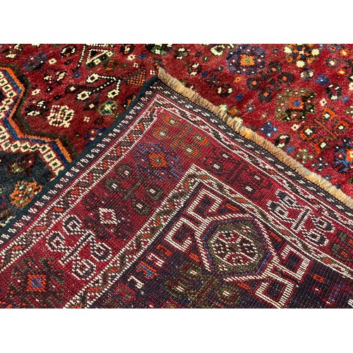 206 - A South West Persian Qashgai Carpet, hand-knotted in deep tones of red, grey, blue, and green, the c... 