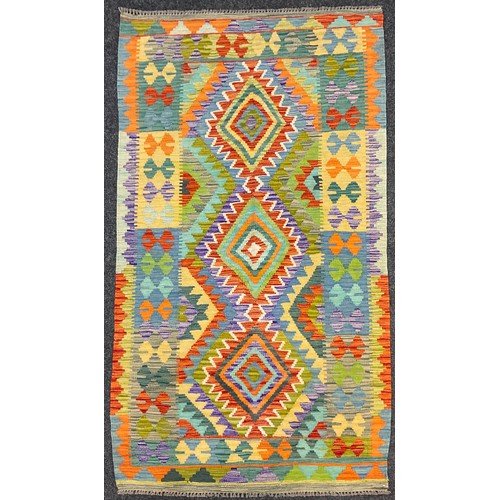 255 - A Turkish Anatolian Kilim rug, knotted with a triple row of diamond-shaped medallions, within a fiel... 