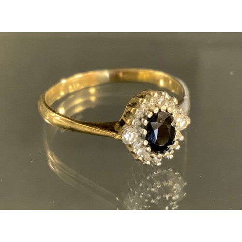 349 - A sapphire and diamond ring, central oval deep blue sapphire approx 0.45ct, sixteen round brilliant ... 