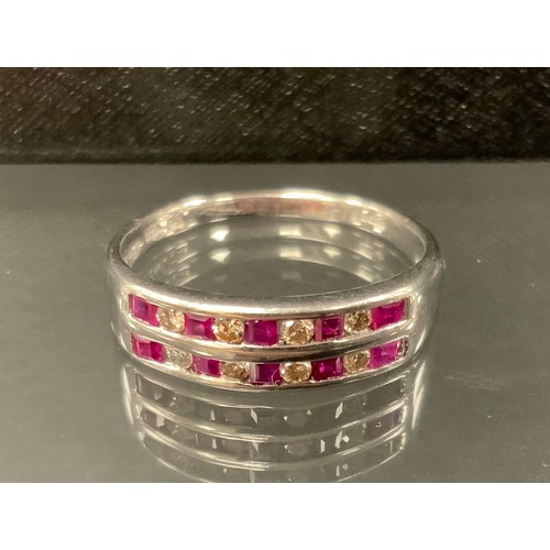 355 - A ruby and diamond ring, with two rows of alternating square step cut rubies and round brilliant cut... 